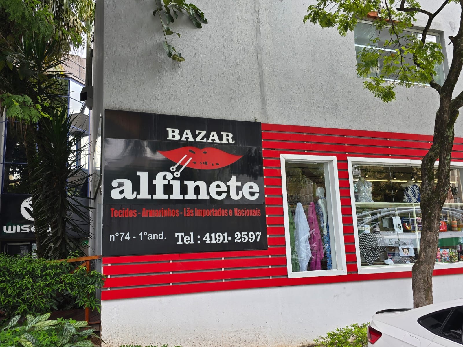 Fachada da loja com a placa Bazar Alfinete — tecidos, armarinhos, lãs importadas e nacionais